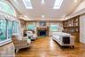 Living room with a skylight, a premium fireplace, light wood finished floors, recessed lighting, and high vaulted ceiling