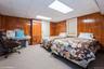 Bedroom with carpet, a drop ceiling, and wood walls