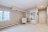 Living area with light colored carpet, baseboard heating, and recessed lighting