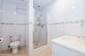 Bathroom with tile walls, a shower stall, vanity, and light tile patterned floors