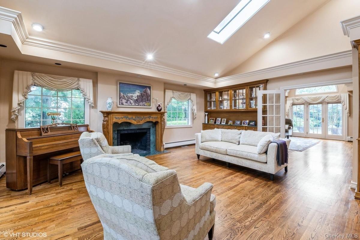Living area with french doors, high vaulted ceiling, light wood-style floors, recessed lighting, and a fireplace