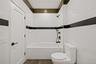 Full bath featuring tiled shower / bath combo, tile walls, and marble finish floors