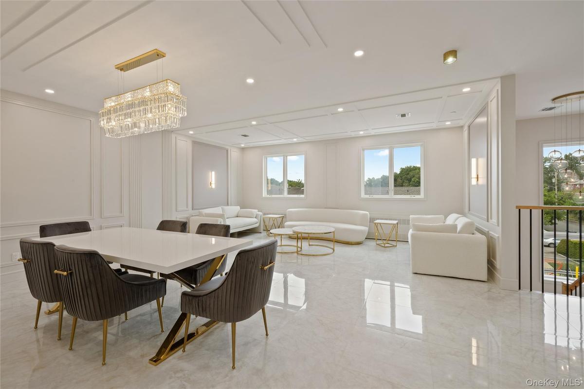 Dining area featuring a decorative wall, a chandelier, recessed lighting, and light marble finish flooring