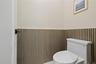 Half bath with a wainscoted wall and toilet
