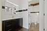 Bathroom with vanity, marble finish floors, and tile walls