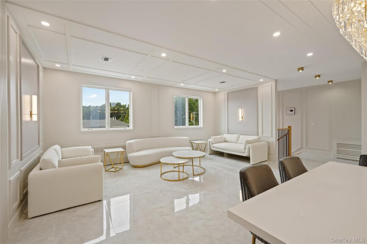 Living room featuring a decorative wall, marble tiled floors, and recessed lighting