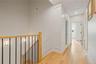 Hall featuring wood finished floors, an upstairs landing, and recessed lighting