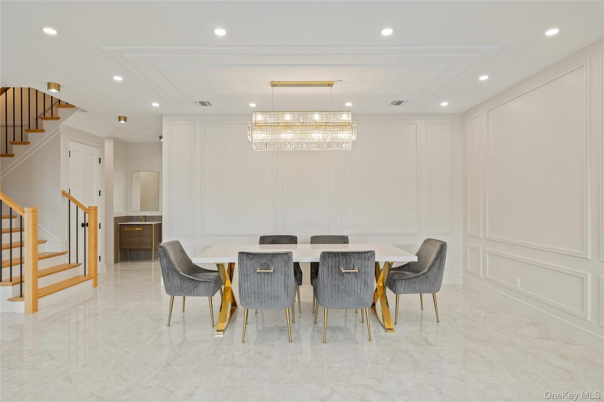 Dining area featuring a decorative wall, recessed lighting, stairs, and light marble finish floors