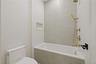 Full bath featuring tile walls and tiled shower / bath