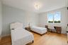 Bedroom with ornamental molding, light wood finished floors, and an office area