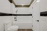 Bathroom featuring  shower combination, marble finish floors, and tile walls