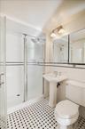Full bathroom featuring tile walls, a shower stall, and tile patterned floors