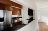 Kitchen featuring dark countertops, stainless steel dishwasher, brown cabinets, and stovetop