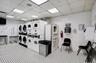 Community laundry room featuring stacked washing machine and dryer, brick wall, light flooring, and separate washer and dryer