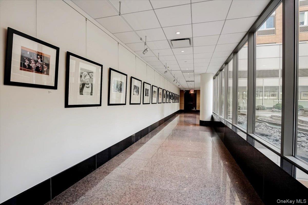 Hallway with baseboards and expansive windows