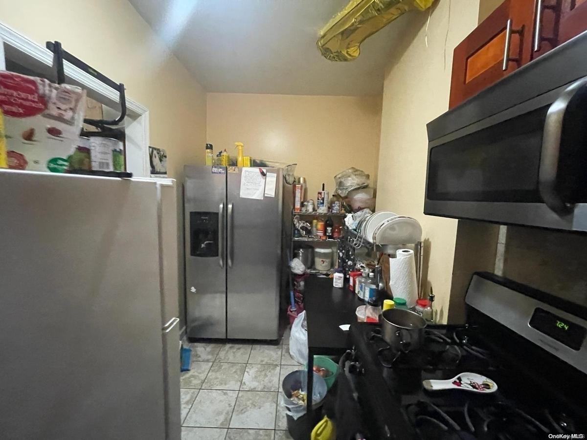 Kitchen with light tile patterned flooring and stainless steel appliances