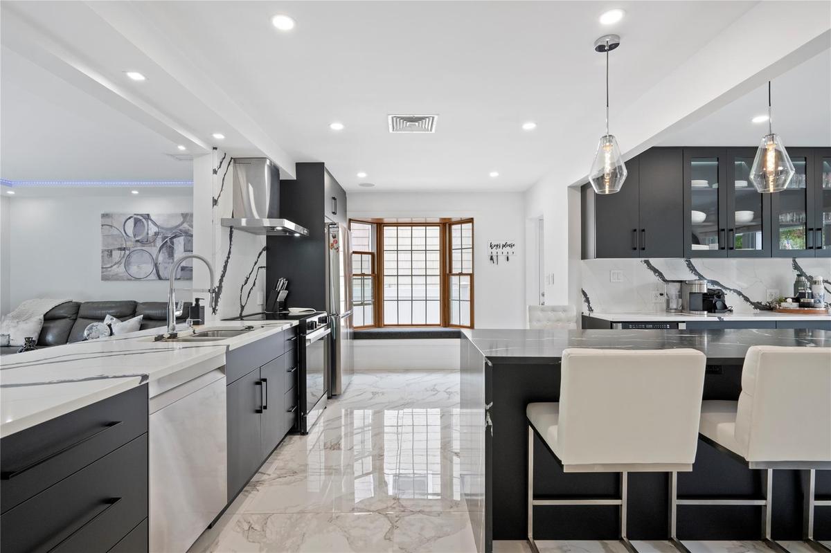 Kitchen with island range hood, dishwasher, electric range, light marble finish floors, and recessed lighting