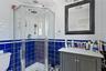 Bathroom with tile walls, vanity, and a stall shower