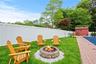 Fenced backyard with a fire pit and a storage unit