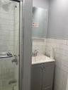 Full bath featuring tile walls, combined bath / shower with glass door, and vanity