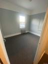 Unfurnished room featuring radiator, baseboards, and dark carpet