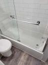 Bathroom with toilet, enclosed tub / shower combo, and wood finished floors
