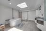 Primary Bathroom with a freestanding tub, vanity, a skylight, recessed lighting, and wood finished floors