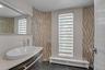 Powder Room featuring tile walls, tile patterned floors, and vanity