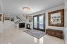 Entrance foyer with crown molding, french doors, light tile patterned floors, and a chandelier