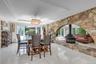 Dining Room with a raised ceiling, a wood burning fireplace, ornamental molding, light tile patterned floors, and a chandelier