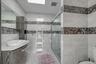 Bathroom featuring tile walls, a stall shower, vanity, and tile patterned flooring
