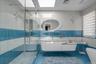 Bathroom featuring tile walls, a shower stall, vanity, tile patterned floors, and a skylight