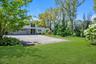View of green lawn featuring asphalt driveway