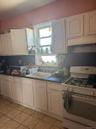 Kitchen with gas range gas stove, decorative backsplash, white cabinets, and dark countertops