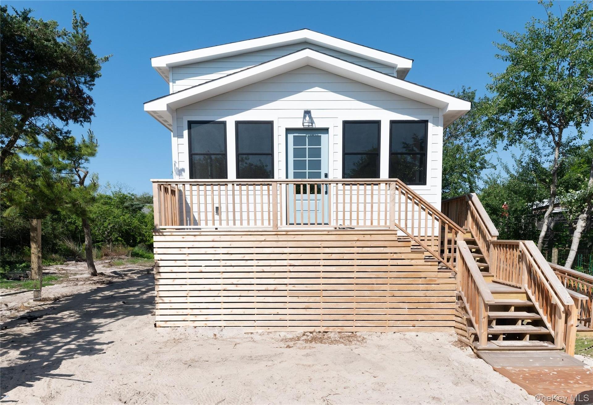 View of front of home featuring stairway and a wooden deck