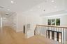 Hall featuring a raised ceiling, light wood-style flooring, recessed lighting, and a decorative wall