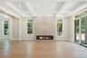 Unfurnished living room with light wood-style floors, beamed ceiling, a fireplace, coffered ceiling, and recessed lighting