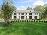 French country home with a front lawn and a balcony