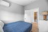 Bedroom with a wall mounted air conditioner and light wood-style floors