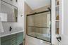 Bathroom featuring shower / bath combination with glass door and vanity