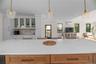 Kitchen featuring pendant lighting, backsplash, open floor plan, and glass insert cabinets