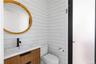 Half bathroom featuring vanity and wood walls