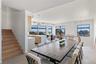 Dining area with plenty of natural light and stairway