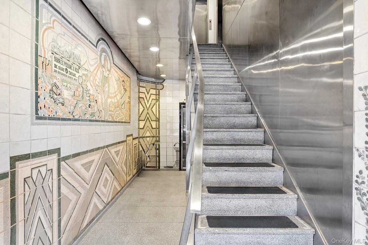Stairs with tile walls and recessed lighting