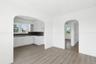 Kitchen featuring dark countertops, white cabinetry, plenty of natural light, and light wood-style flooring
