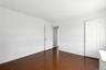Unfurnished bedroom with dark wood-style floors and baseboards