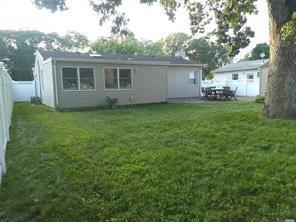Back of house with a yard and a fenced backyard