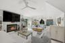 Living area featuring a glass covered fireplace, lofted ceiling, recessed lighting, and ceiling fan