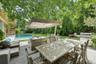 Fenced backyard featuring a patio, outdoor dining area, view of scattered trees, and outdoor lounge area