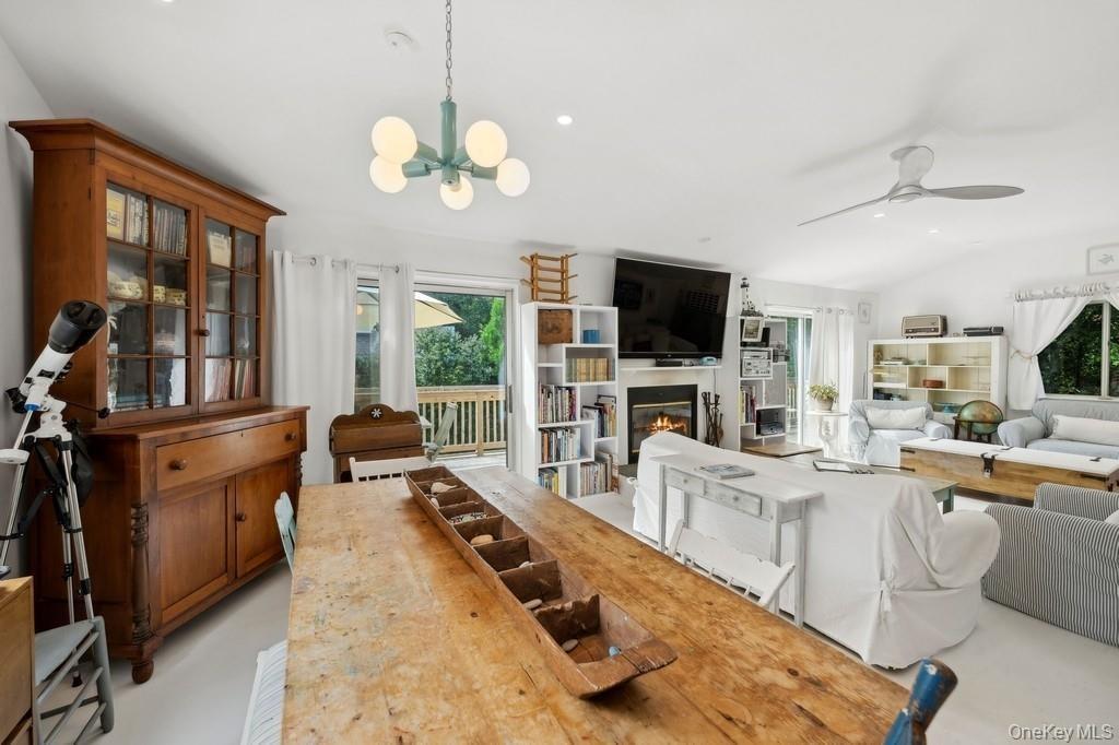 Dining room with a glass covered fireplace, ceiling fan, recessed lighting, and a chandelier